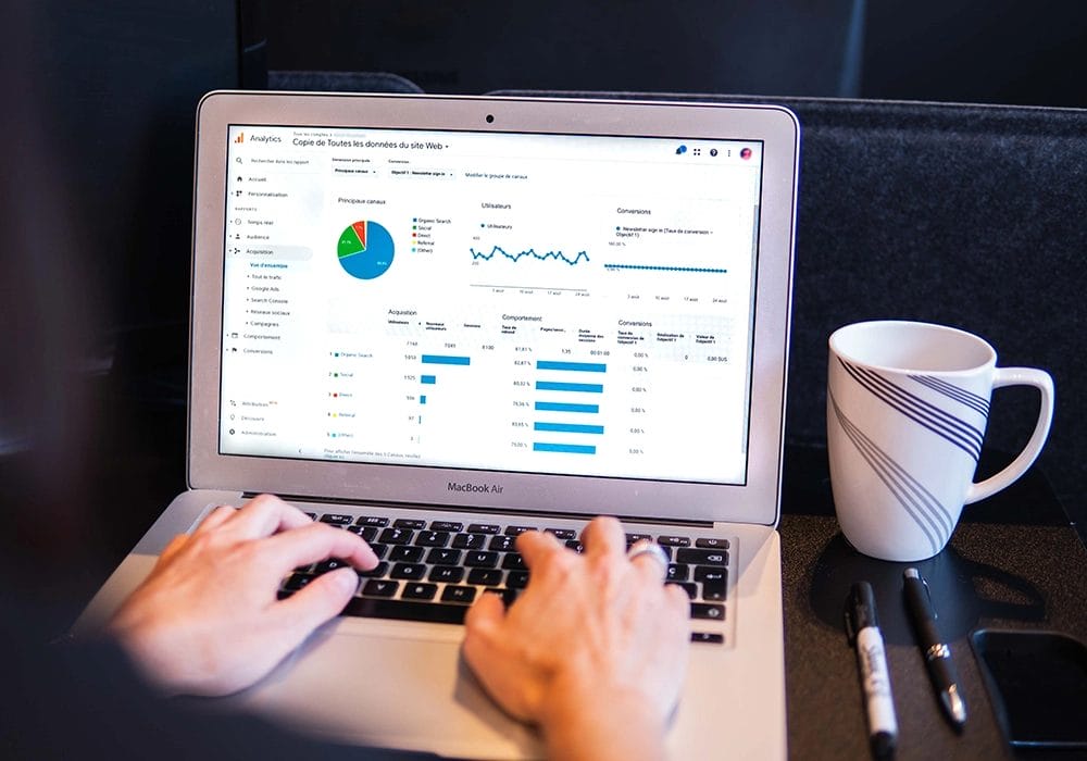 A person using a laptop to analyze graphs for customer conversion rate.