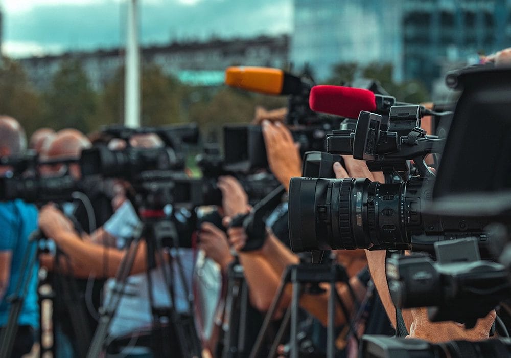 Social proof examples of a group of people holding cameras and microphones.