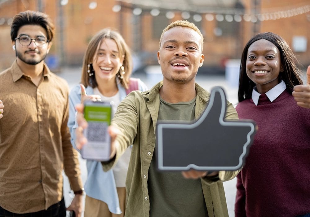 A group of people displaying social proof by holding up a thumbs up sign.