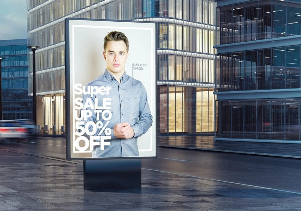 A traditional billboard with a man standing in front of it, showcasing the power of traditional advertising.