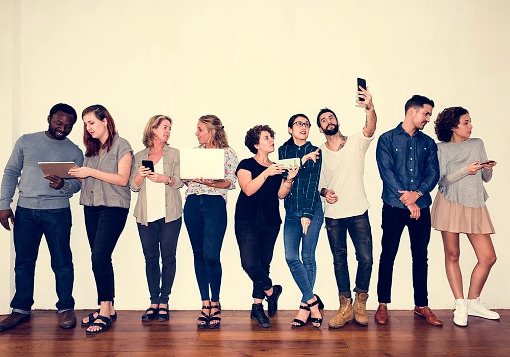 A group of people showcasing social proof in front of a white wall.