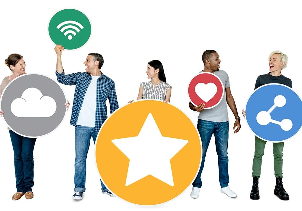 A group of people demonstrating social proof by holding up social media icons.