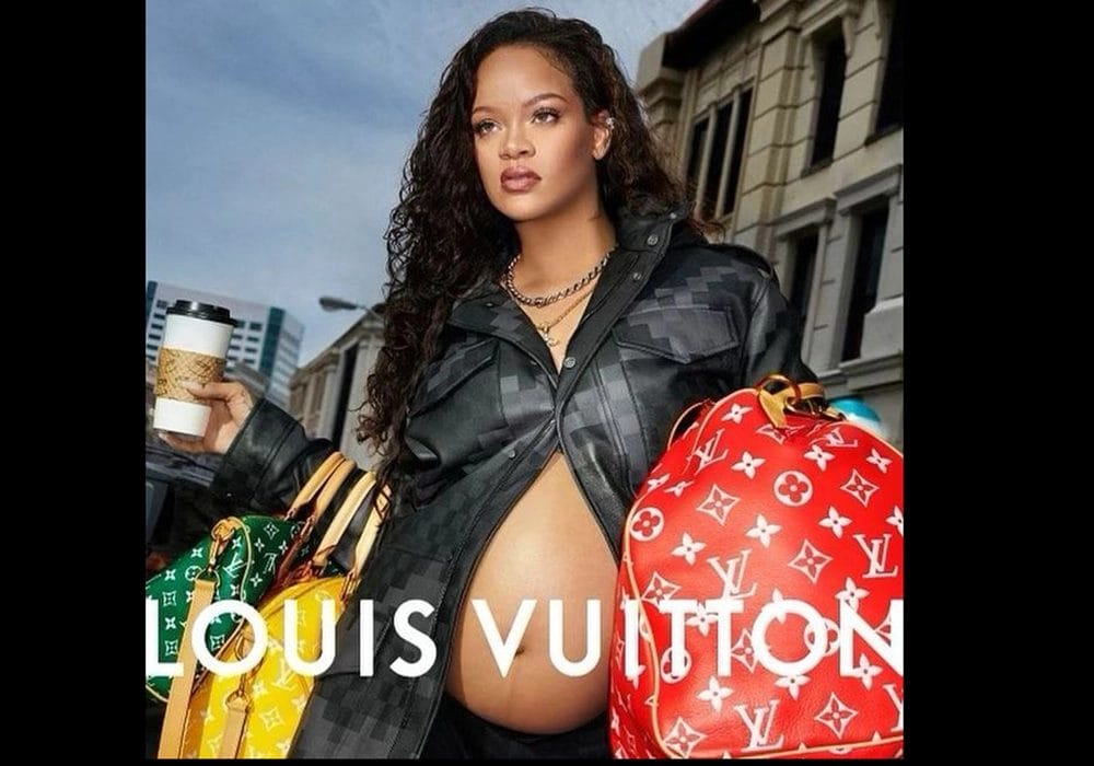 Rihanna posing with a coffee cup and louis vuitton bags, showcasing her baby bump in a stylish outfit.