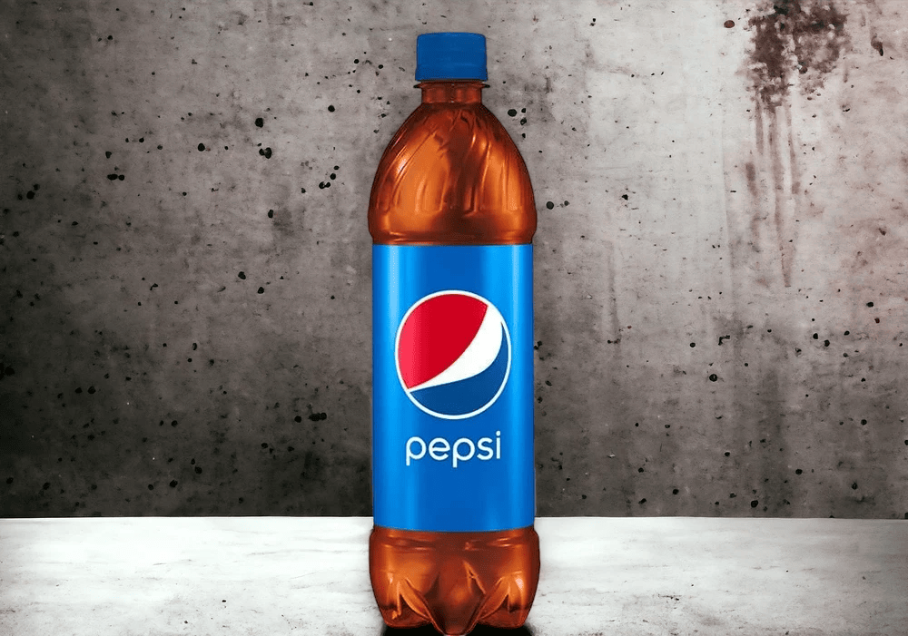 A plastic Pepsi bottle, often seen in celebrity endorsements, stands on a concrete surface against a speckled gray wall.