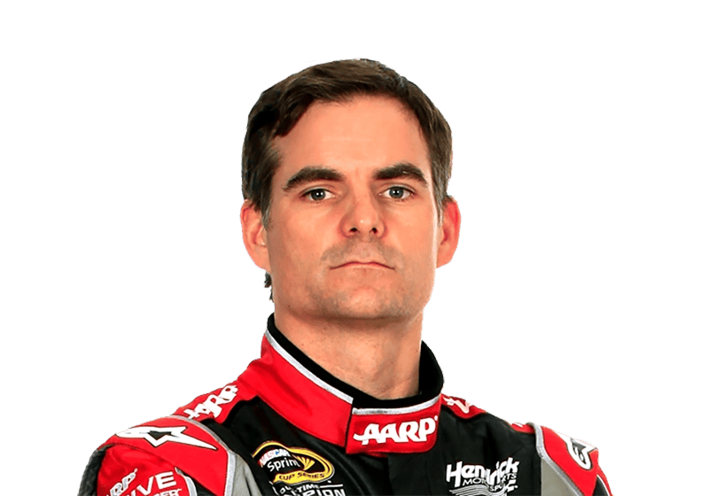 A person wearing a red and black racing suit looks directly at the camera with a neutral expression, embodying the cool confidence often seen in NASCAR celebrity endorsements.