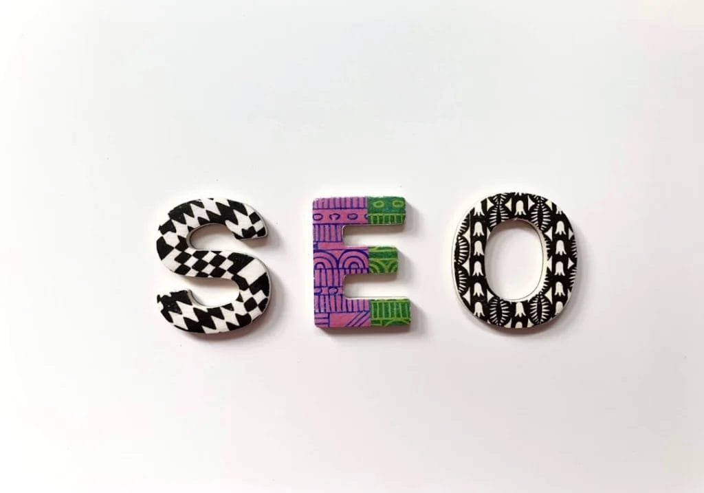 The letters "SEO," crafted with elaborate patterns and colors, displayed on a plain white background, evoke the dynamic world of digital marketing.