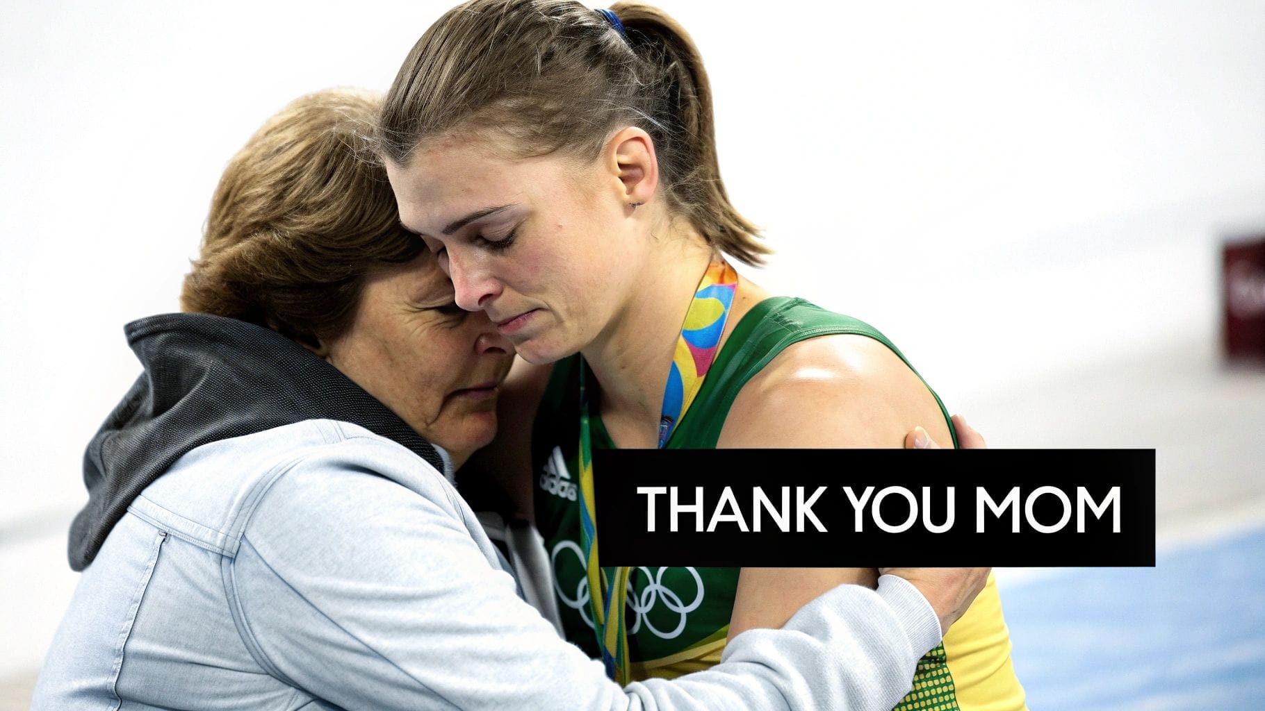 A female athlete wearing an Olympic medal hugs an older woman; both look emotional in this powerful emotional advertising example. Text on the image reads, "THANK YOU MOM.