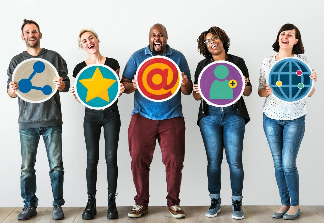 Five people stand in a row holding large icons representing social media and online connectivity, including share, star, at symbol, user, and globe icons.